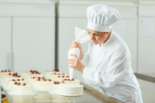 Confectioner Decorating Cake In Pastry Shop.