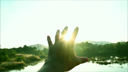 Wall Mural - Use hand to touch the light of sunrise, Beautiful sun rise in winter, Hand of man are moving to touch flare light,  Hand symbols to show the hope, believes, New day starting, Body language