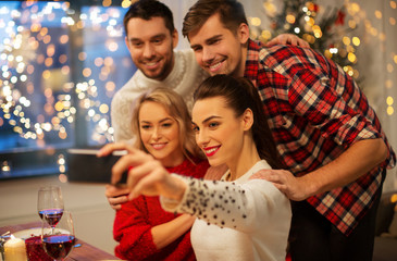 Sticker - holidays and celebration concept - happy friends taking selfie by smartphone at home christmas dinner