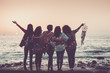 © simona - Love friendship and celebration time concept image with group of women friends viewed from back enjoying the beautiful coloured sunset in front of the ocean - feeling with nature and joyful for world