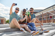 © Syda Productions - leisure, technology and people concept - happy male friends taking selfie by smartphone and drinking beer on street in summer