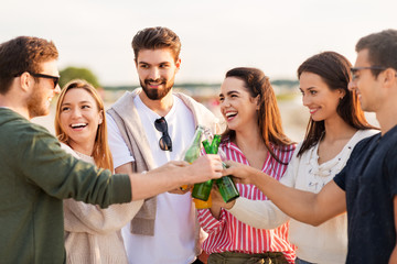 Canvas Print - friendship and leisure concept - group of happy friends toasting non alcoholic drinks on summer beach