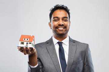 Sticker - real estate business and people concept - indian man realtor with house model over grey background