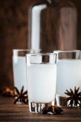 Wall Mural - Ouzo - Greek anise brandy, traditional strong alcoholic drink in glasses on the old wooden table, place for text