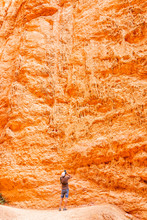Man Taking Picture Of Hoodoos Orange Rock Formations Vertical View At Bryce Canyon National Park In Utah Queens Garden Navajo Loop Trail
