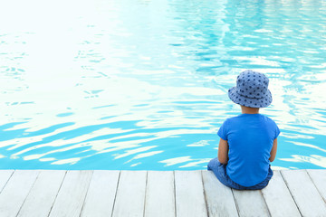 Poster - Little child near outdoor swimming pool. Dangerous situation