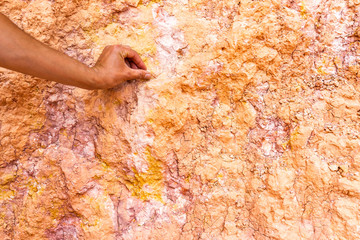 Man touching orange rock formations wall closeup at Bryce Canyon National Park in Utah Queens Garden Navajo Loop trail