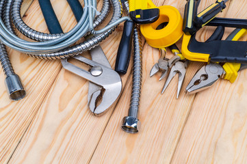 Necessary set of tools for plumbers on wooden background