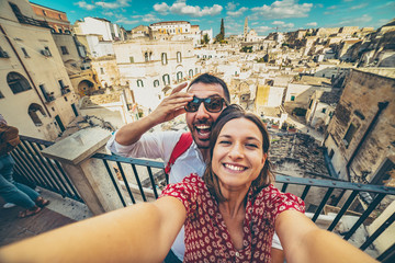 Wall Mural - happy tourist travelling in south of italy, posing in a selfie photo in Matera, Basilicata, unesco site, capital of culture 2019