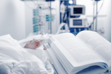 Wall Mural - Open book on the background of a patient under 24-hour monitoring of the condition, unfocused background.