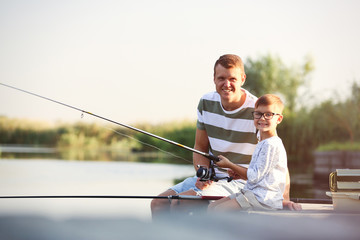 Wall Mural - Dad and son fishing together on sunny day