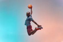 Slam Dunk. Full Length Of Young African Backetball Player Jumping Against Colorful Background