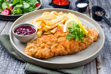 Deep Fried Wiener Schnitzel From Veal Topside With French Fries And Lettuce As Closeup Modern Design Plate