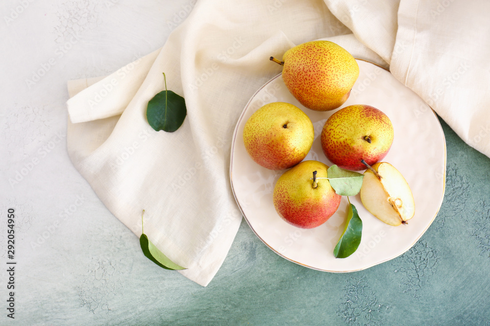 Plate with tasty fresh pears on light background