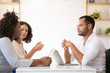 © Mangostar - Partners discussing software product. Man and women in casual sitting at table with laptops and talking. Business meeting concept