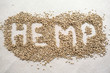 Word HEMP made of hemp seeds on linen background. Healthy eating supplement. Superfood concept. Top view.