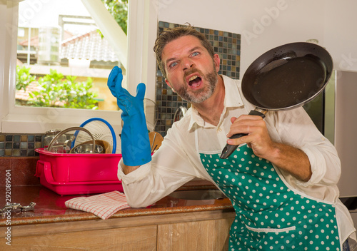 unhappy and stressed man in kitchen apron feeling frustrated and upset overwhelmed by domestic chores washing dishes tired screaming desperate in stress