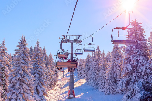 Fotomural Panorama of ski resort, slope, skiers on the ski lift, white snow pine trees at