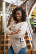 © Mangostar - Beautiful African American woman posing at library. Front view of smiling lady with dreadlocks posing in front of stairs. Knowledge concept