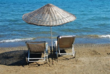 two chairs and umbrella on the beach