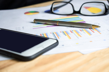 Poster - A side view of the financial graph of a business man on a wooden table. Financial concept. Close up.