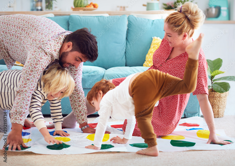 happy family having fun together, playing twister game at home - obrazy, fototapety, plakaty 