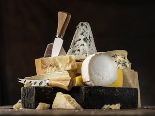Wall Mural - Assortment of different cheese types on wooden background. Cheese background.