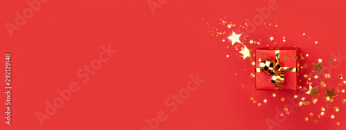 Banner with red gift box with golden bow on red background decorated golden s...
