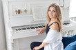 Beautiful young girl musician near a white piano