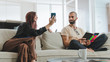 © creative_content - Millennial couple in love relaxing together on sofa at home.