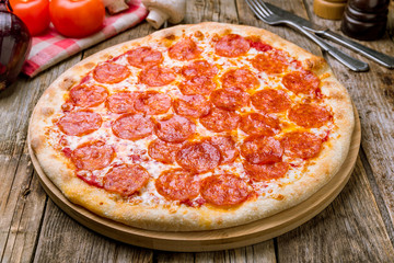 Wall Mural - Pepperoni pizza on wooden table