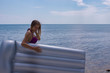 fascinating young girl in swimsuit and with air mattress on the beach