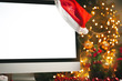 © fotofabrika - Wooden desk with computer with blank screen against blurred christmas lights background