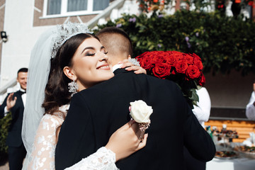 First meet of bride and groom on their wedding day. Happy smile bride and groom. Beautiful bouquet red roses. Wedding. Bride and groom, Happy newlyweds woman and man. Wedding concept