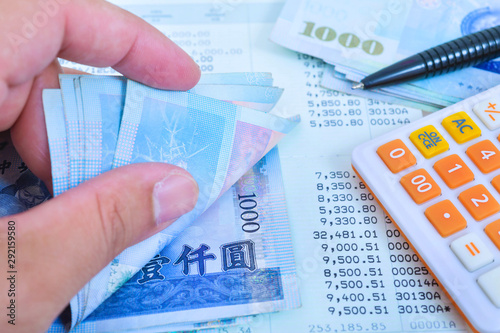 Cuadros en Lienzo Man hand during counting banknote Taiwan dollar bills