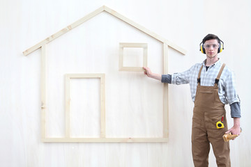 house construction renovation concept handyman carpenter worker man show the model of a wooden house