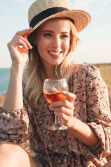 Poster - Photo of cheerful pretty woman holding wine glass and smiling