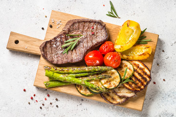 Canvas Print - Grilled meat with vegetables on white stone table.