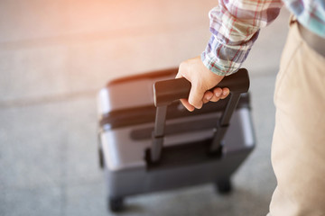 businessman walking outside public transport building with luggage in rush hour. Business traveler pulling suitcase in modern airport terminal. baggage business Trip.  Copy space , top view