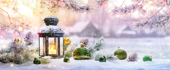 Wall Mural - christmas lantern on snow with fir branch in the sunlight