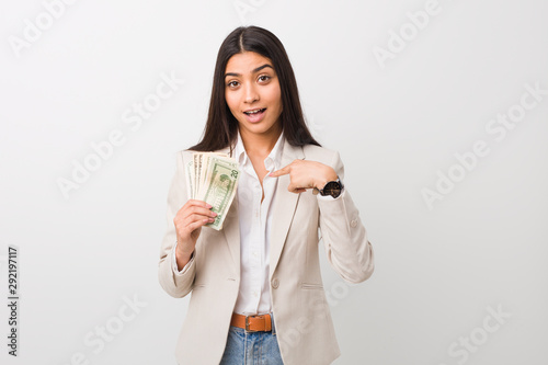 Cuadros en Lienzo Young arab business woman holding dollars surprised pointing at himself, smiling broadly