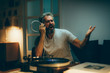 © cherryandbees - mid aged man playing records on gramophone and singing at his home. night scene