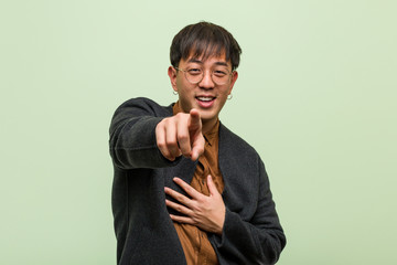 Young chinese man wearing a cool clothes style against a green background