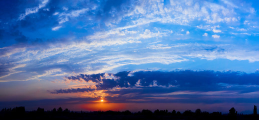 Wall Mural - bright sunlight through the clouds against a breathtaking evening sky at sunset. panorama, natural c
