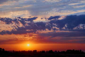 Wall Mural - bright sunlight through the clouds against a breathtaking evening sky at sunset. panorama, natural c