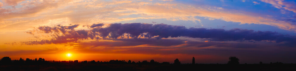 Wall Mural - bright sunlight through the clouds against a breathtaking evening sky at sunset. panorama, natural c