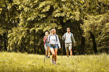Wall Mural - group of friends hiking in nature.girl with blond hair lead the group.