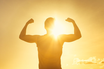 Wall Mural - Strong man flexing in the sunshine. Strength, fitness and determination. 