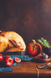 Festive table for Thanksgiving Holiday with whole roasted turkey with apple, pumpkin, figs and herbs in a mortar.