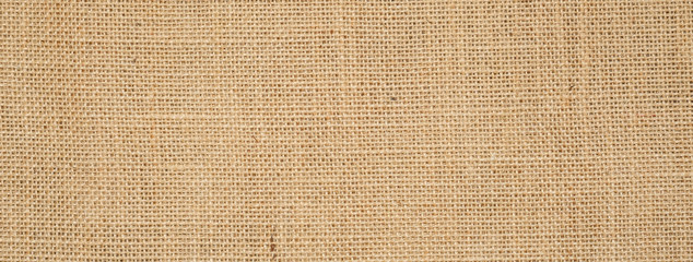 Wall Mural - Cotton woven fabric background with flecks of varying colors of beige and brown. with copy space. office desk concept / Hessian sackcloth burlap woven texture background